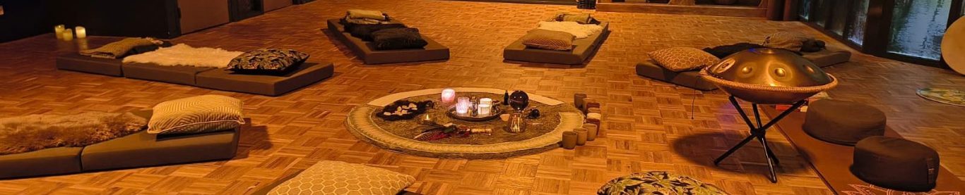 een meditatieruimte voor een sessie met kussens en in het midden begeleidend materiaal